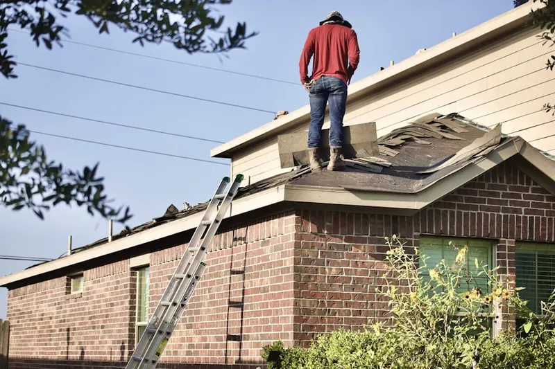Professional roofer working on a residential roof in Guda